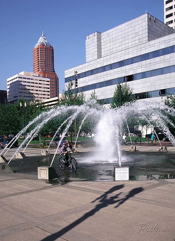 Boy bicycles through Salmon Street Fountain near KOIN tower, Portland